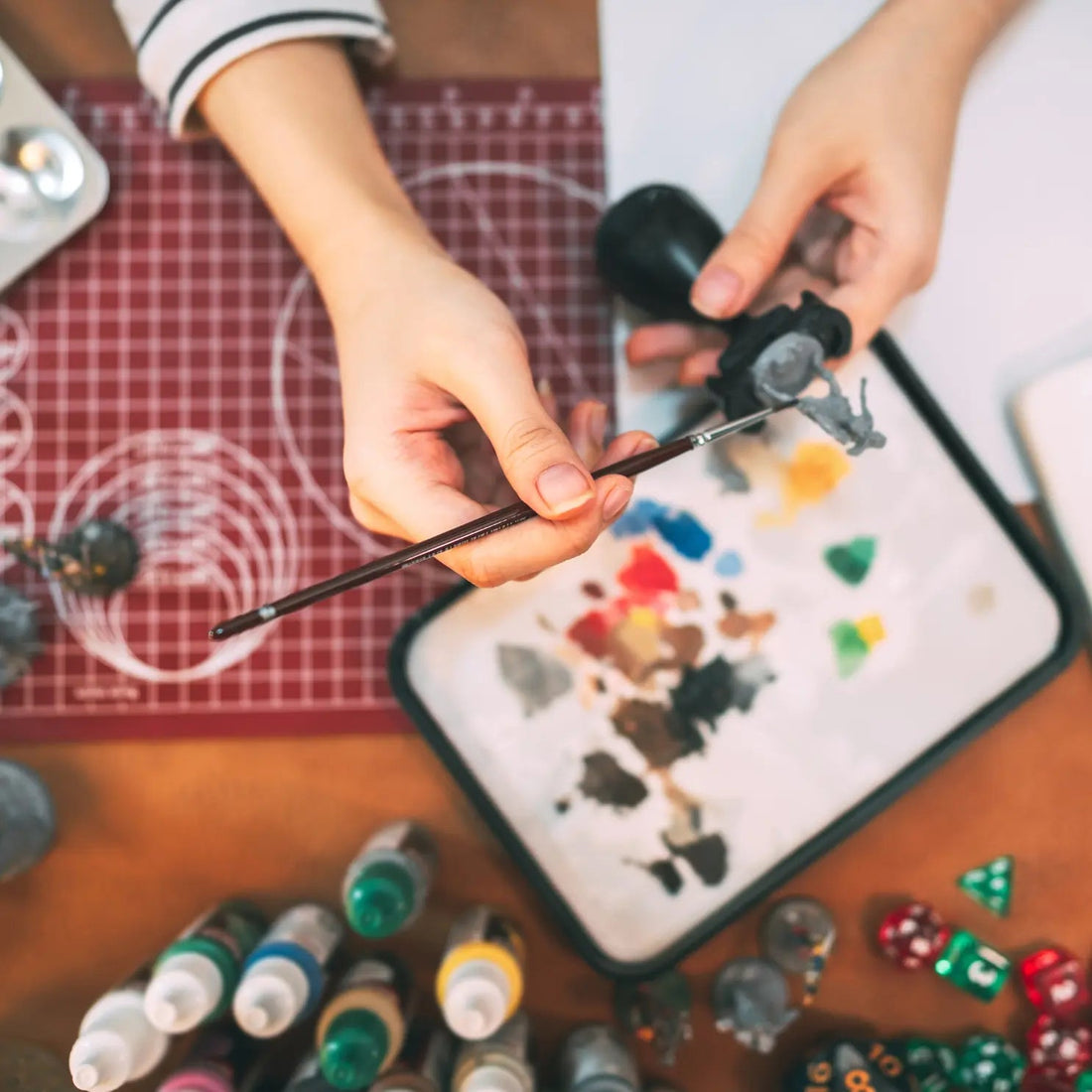 A close up of a hobbyist miniature painting using a wet palette.