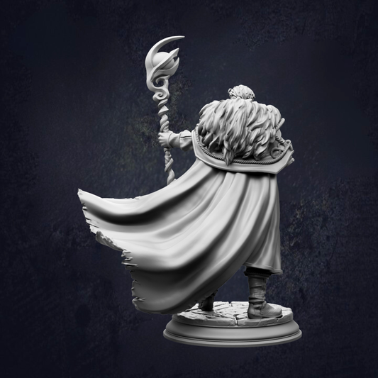 A statue of a person with long hair and a flowing cape, holding a staff or staff-like object, standing against a dark background.
