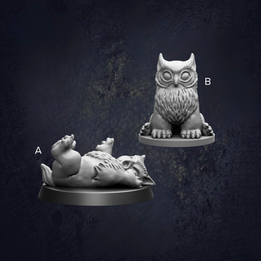 two small figurines of animals, one of which is an owl, placed on a dark background.