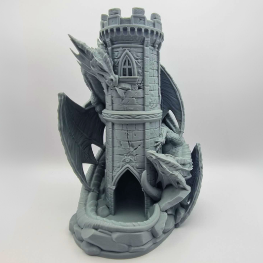A gray, castle-like structure with a tower and two dragon heads, one on top of the tower and the other on the ground.