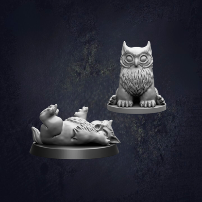 two small figurines of owls, one sitting upright and the other lying down.