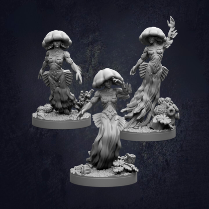 three figurines of fantastical creatures, including jellyfish-like figures with large, flowing hats and intricate, detailed costumes.