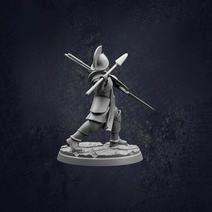 A 3D model of a warrior figure holding a spear and shield, standing on a rocky base against a dark background.