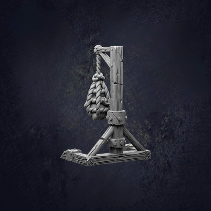 A wooden trebuchet with a rope and a bundle of ropes hanging from it, set against a dark background.