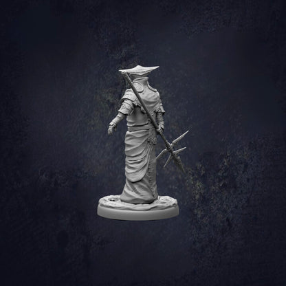 A statue of a figure holding a spear and shield, standing against a dark background.