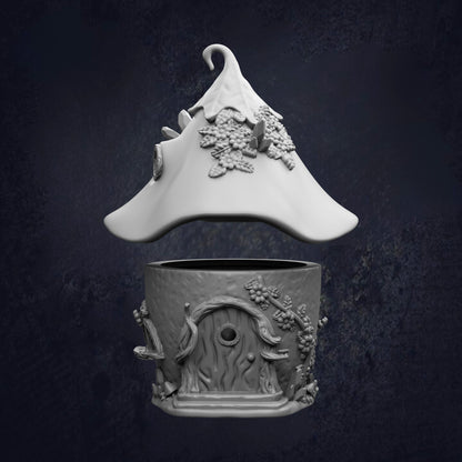 A white ceramic figurine of a whimsical, fantastical hat with intricate floral designs, and a small, round ceramic container with a similar, whimsical design.