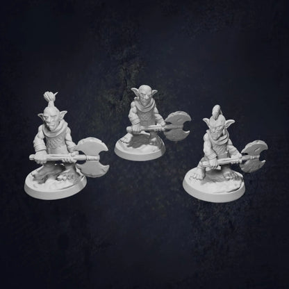 Three unpainted 3D-printed RPG miniatures of goblins wielding double-headed axes, each with unique hairstyles (ponytail, bald, mohawk), posed on round bases against a dark background. Perfect for DnD, tabletop RPGs, and wargaming, these high-quality resin miniatures are ideal for collectors, painters, and fantasy gaming enthusiasts.