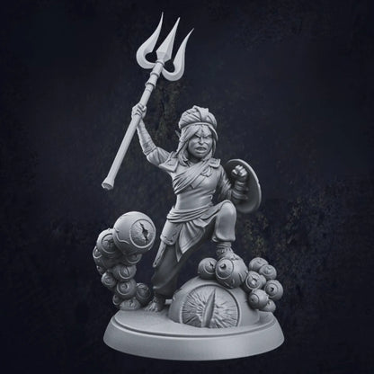 A highly detailed 3D-printed miniature figurine, designed by TPK Labs, featuring a warrior with an intricate, ornate style. The warrior is clad in a flowing robe and turban-like headgear, wielding a trident in the right hand and a shield in the left. The base of the figurine is circular and strikingly unique, decorated with multiple sculpted eyeballs, adding an eerie and fantastical aesthetic. The miniature is crafted from resin  showcasing fine craftsmanship.
