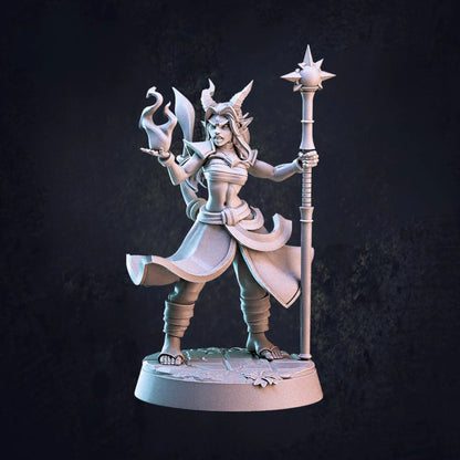 Model C - An unpainted 32mm scale miniature of a female Tiefling sorcerer by Cast N Play, standing on a 25mm round base. She is posed dynamically, holding a fiery spell in front of her with one hand while gripping a staff to her side with the other. Her flowing robes, curved horns, and intricate details emphasize her arcane prowess. With a confident stance and focused expression, she appears ready to unleash powerful magic