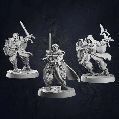Three male human paladin miniatures at 32mm scale designed by Cast N Play, each on 30mm bases. The first paladin is holding a sword with both hands, ready for combat. The second paladin stands in a battle pose, holding a sword and shield, displaying a defensive stance. The third paladin, also in a battle pose, is hooded and holds a sword and shield, with a more mysterious and vigilant appearance.