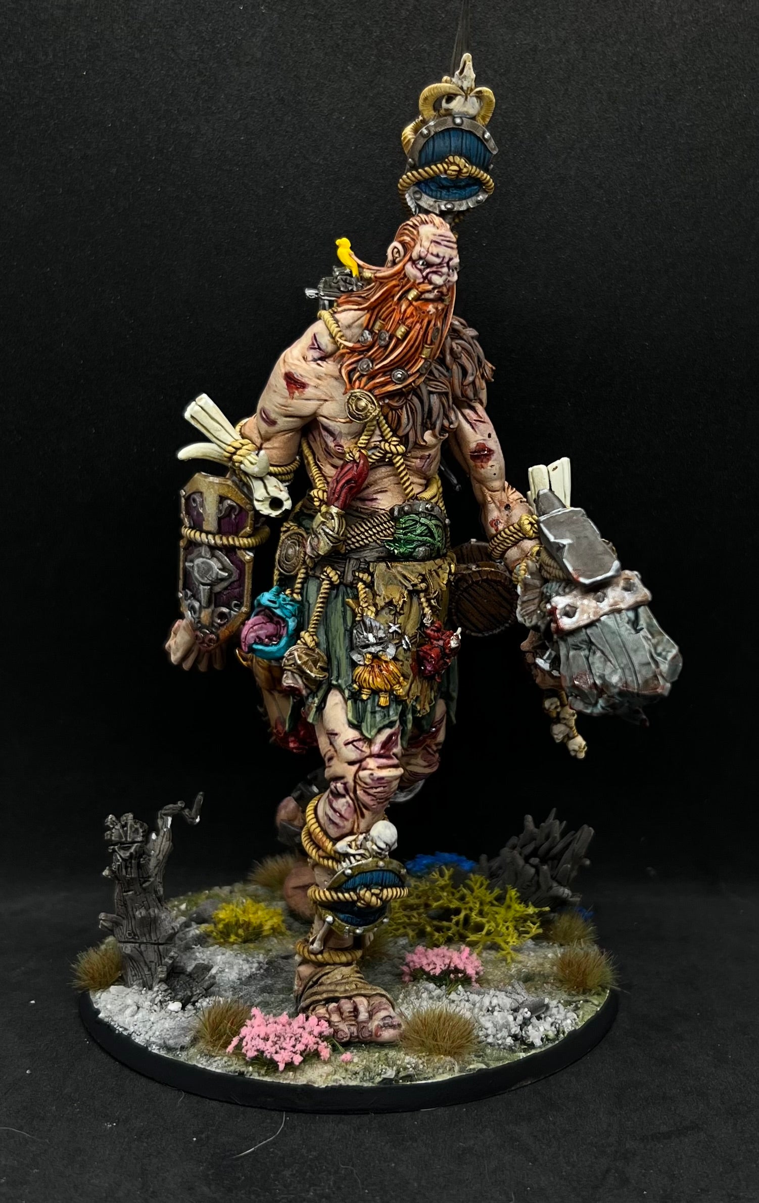 A detailed and intricate model of a fantastical creature, possibly a mythical or magical being, standing on a base with various accessories and weapons.