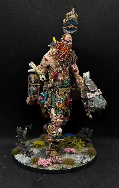 A detailed and intricate model of a fantastical creature, possibly a mythical or magical being, standing on a base with various accessories and weapons.