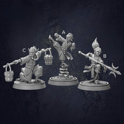 three figurines of characters, each with different poses and weapons, arranged in a row against a dark background.
